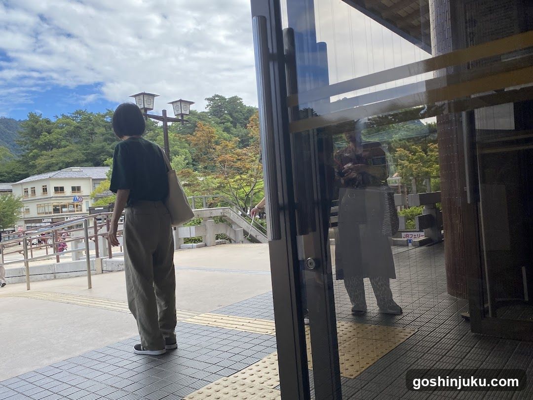 Person at entrance with reflection in glass door