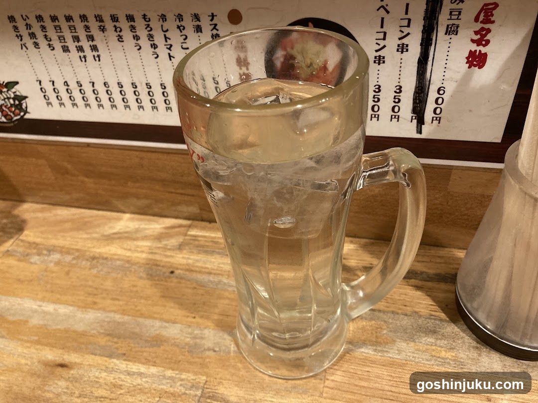 Glass of water with ice on wooden table