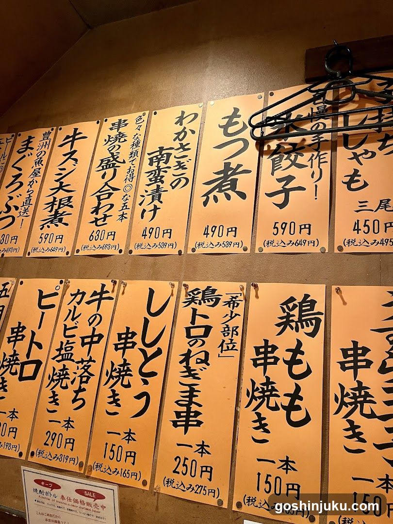 A wall-mounted menu board displaying various Japanese noodle dishes with prices in yen, including Momozuke, Yakisoba, and other ramen styles.