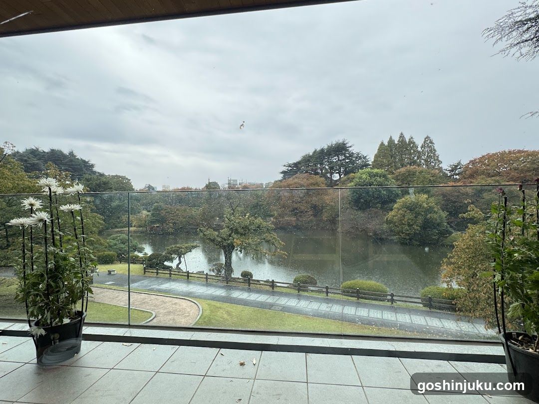 View from a balcony overlooking a park with a lake