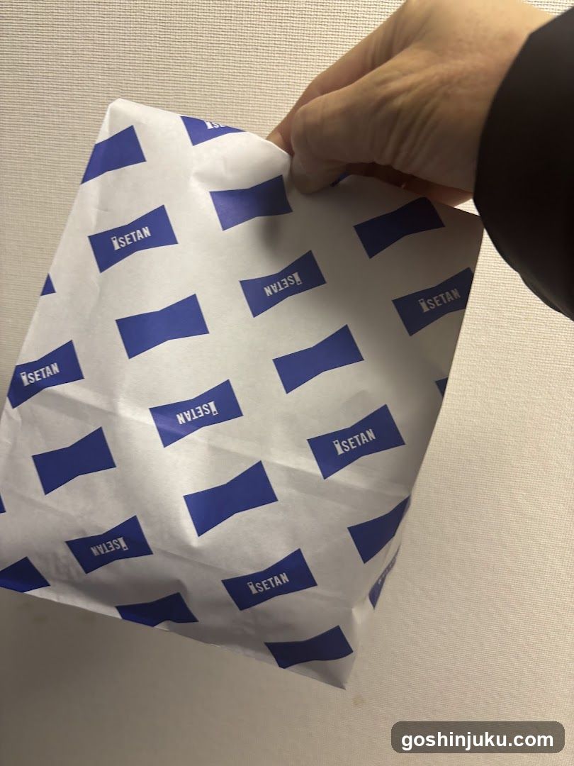 Hand holding branded paper bag