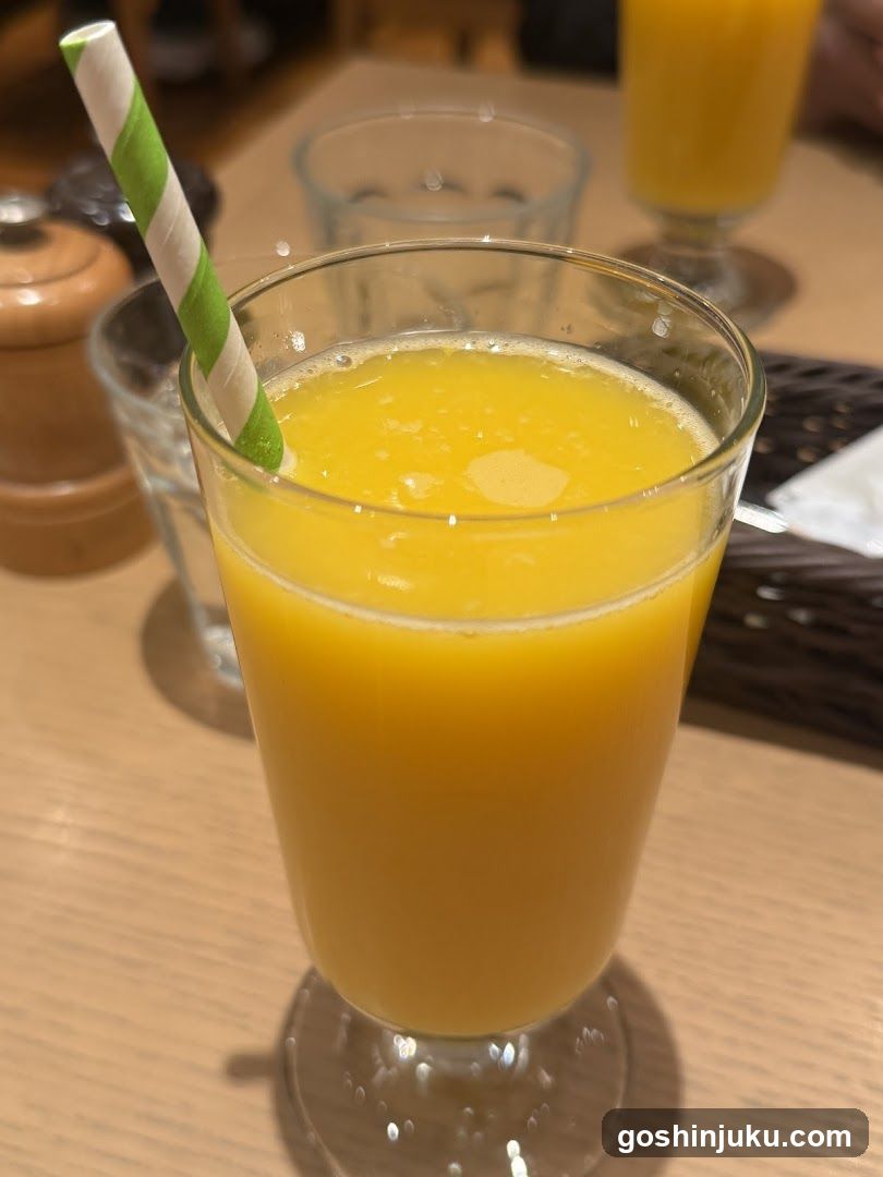 Glass of Orange Juice with Striped Straw