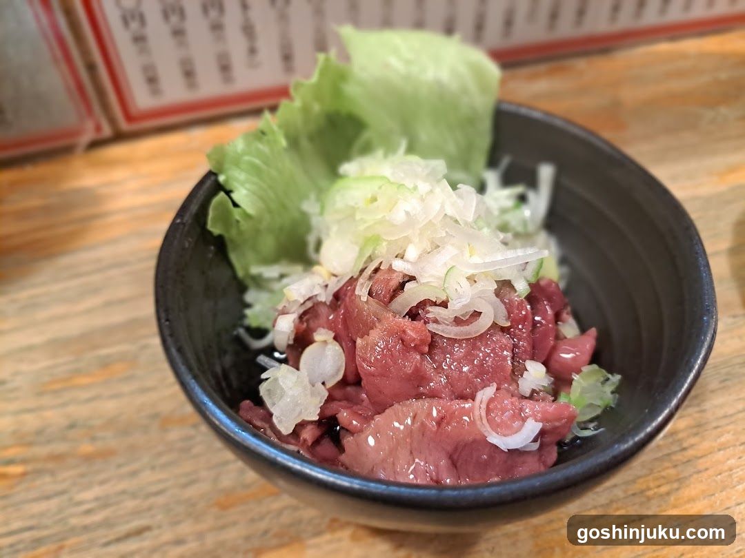 Bowl of raw beef with lettuce and onions