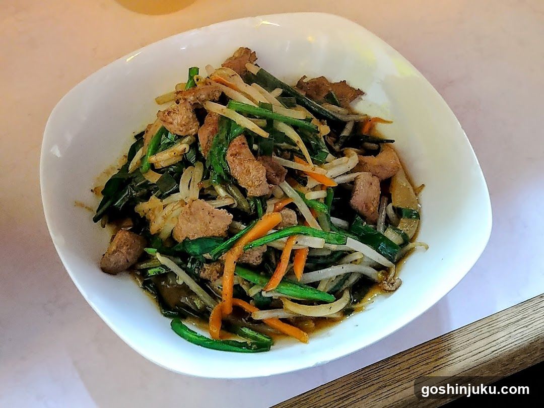 Stir-fried vegetables with meat in a white bowl