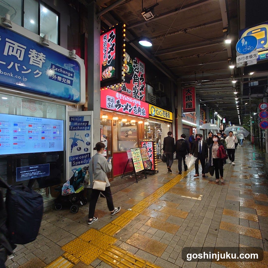 Night street scene with shops and pedestrians