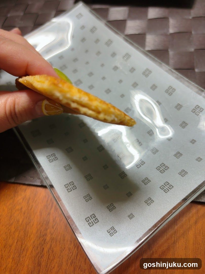 Hand holding a pastry over a patterned plate