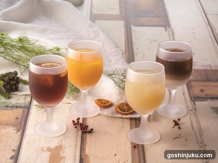 Four glasses of colorful beverages on a rustic wooden table