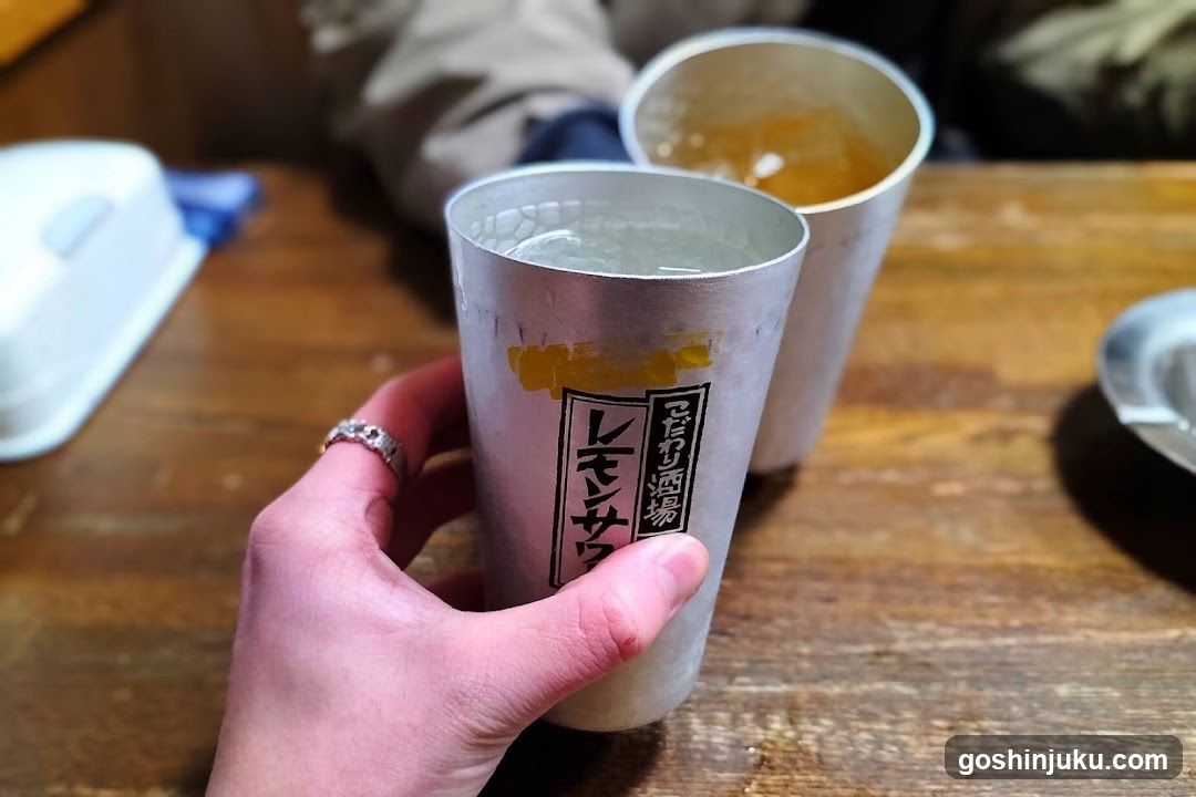 Hand holding a metal cup with Japanese text