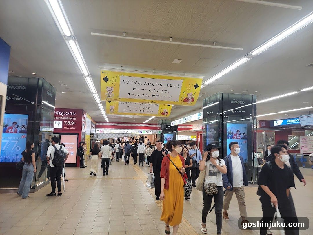 Crowded indoor corridor with signage and people