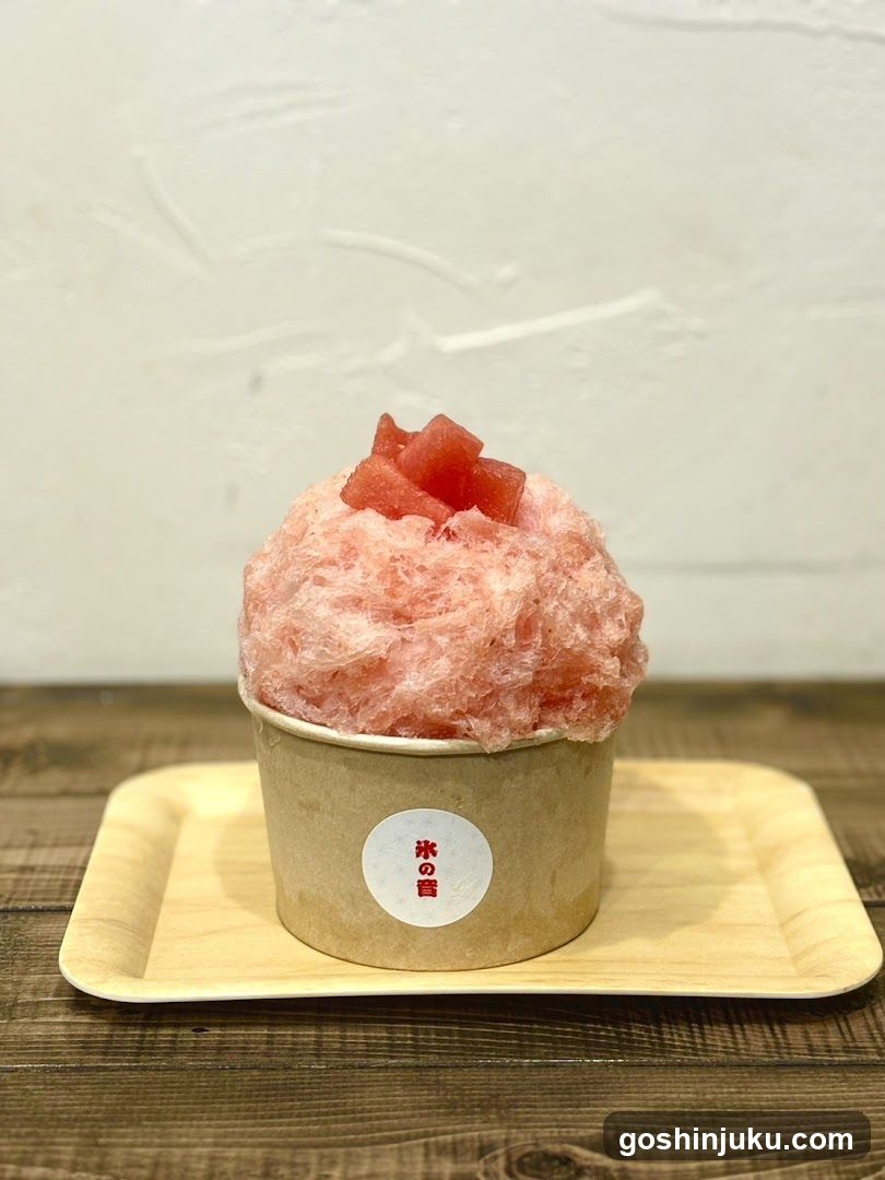 Pink shaved ice dessert with watermelon cubes