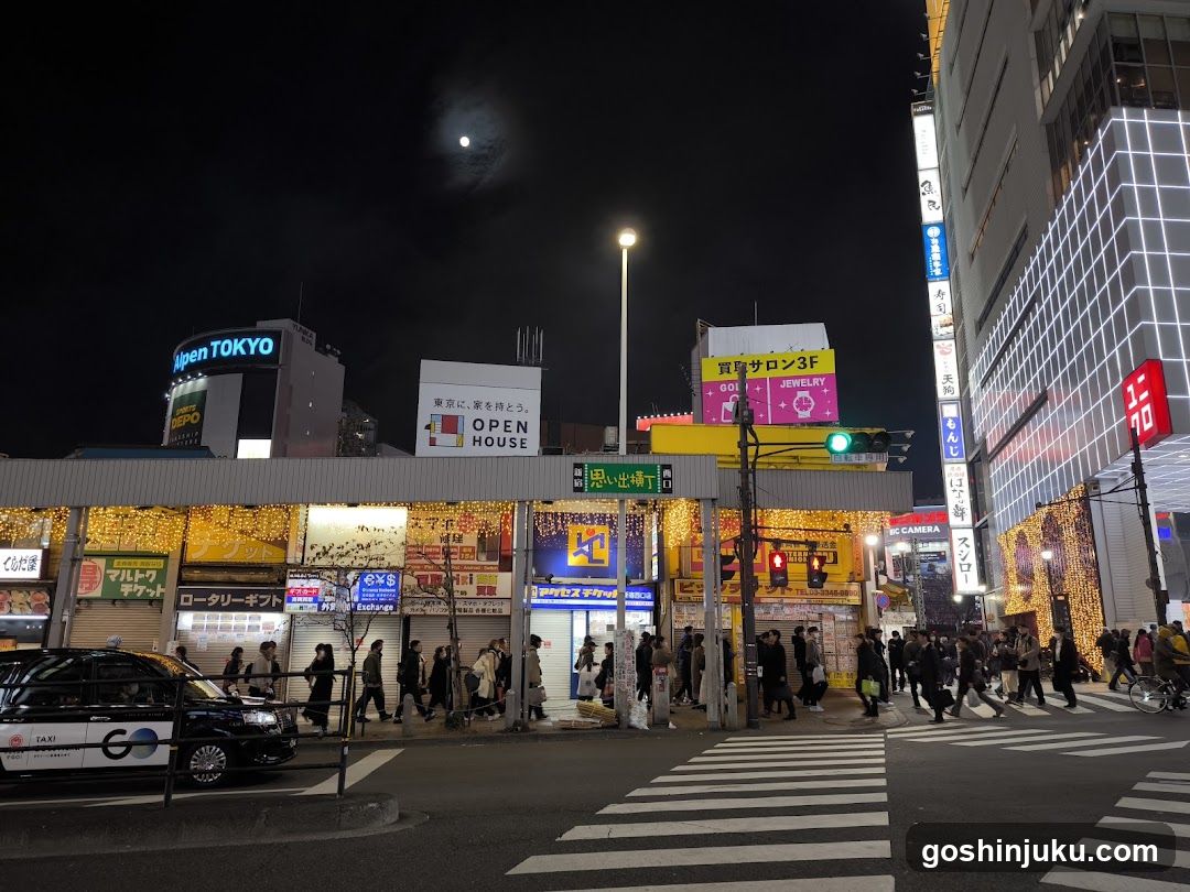 Night street scene with illuminated buildings and pedestrians