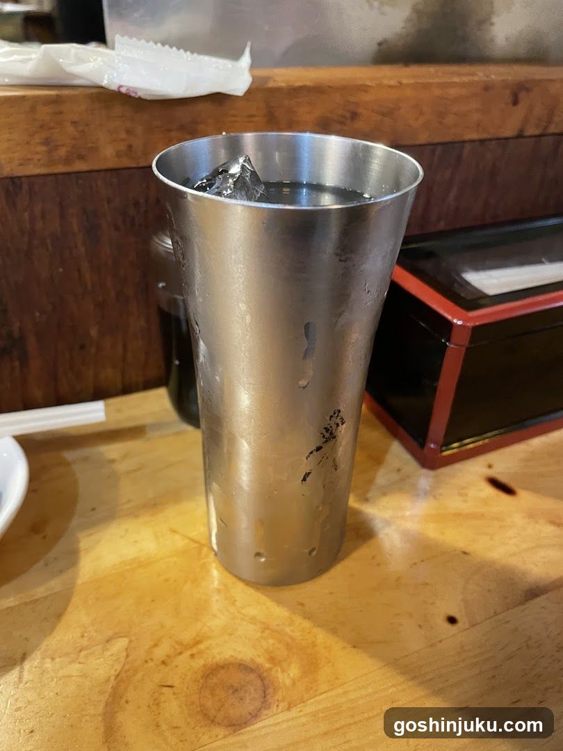 Metal Shaker with Ice on Wooden Table