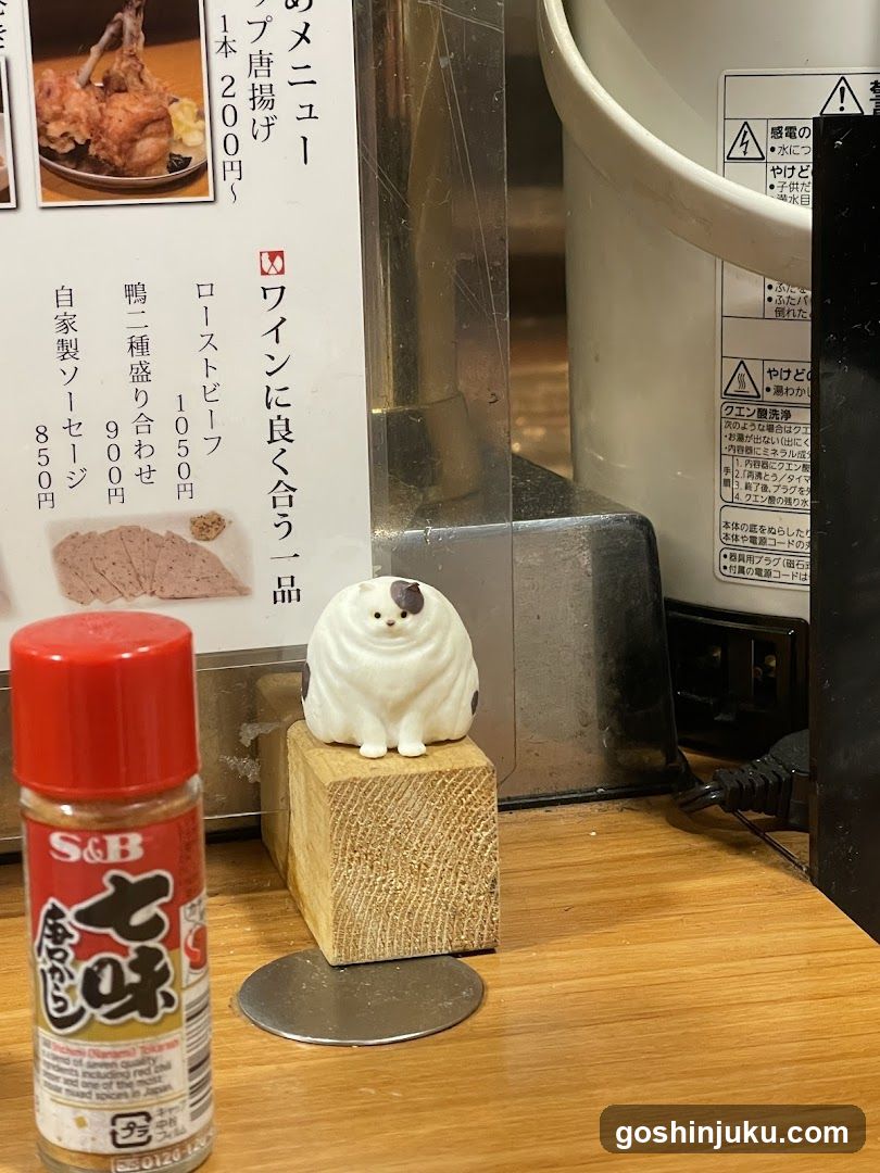 Cat figurine and seasoning bottle on counter