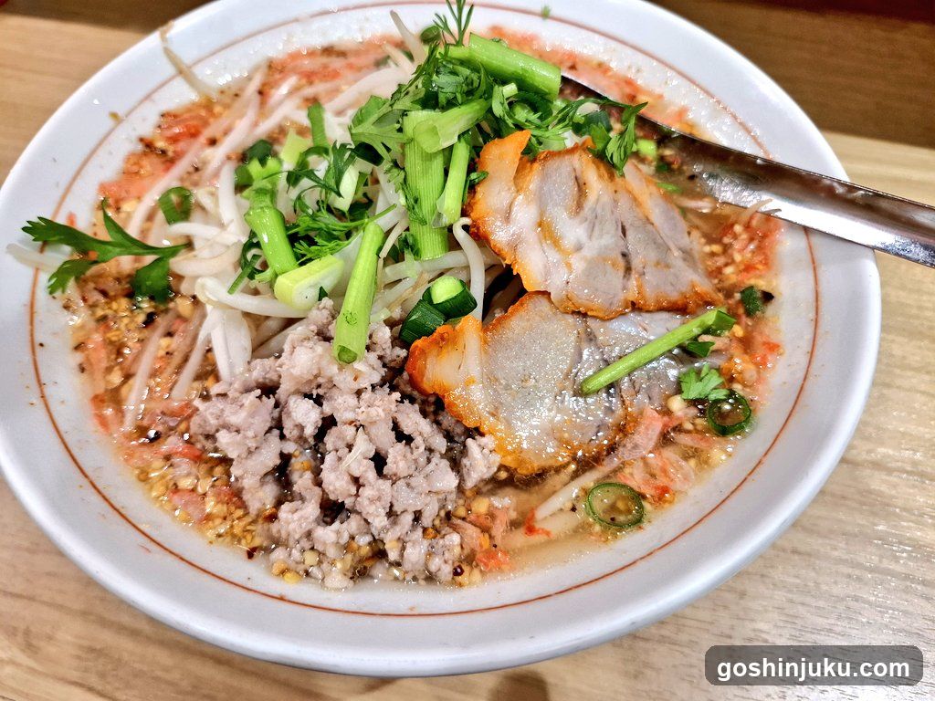 Bowl of Thai-style noodle soup with pork and herbs