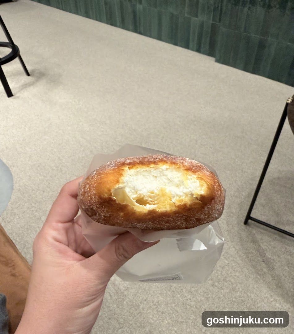 Hand holding a bread roll with cream filling