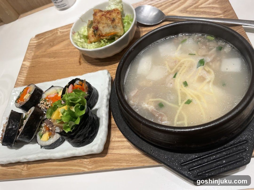 Korean-style meal with soup and sushi rolls