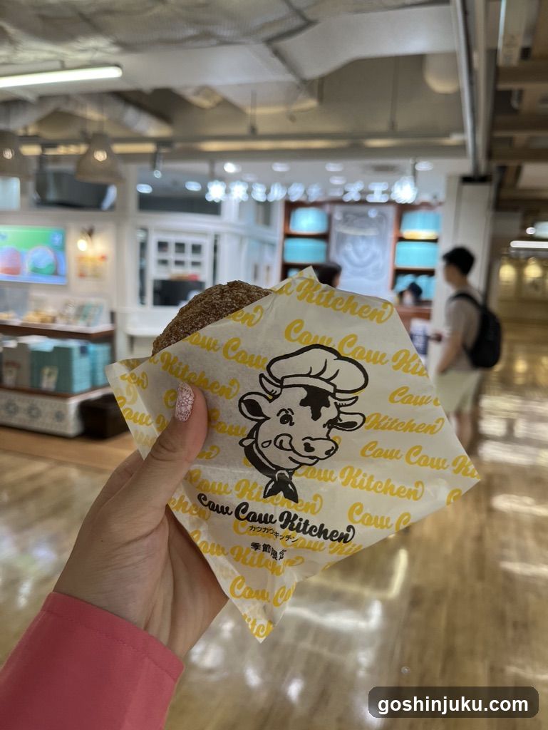 Hand holding Cow Kitchen pastry in mall