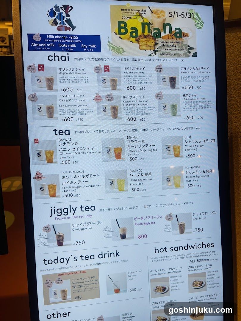 A digital menu board displaying a variety of drinks and food items, including chai, tea, jigjly tea, today's tea drink, hot sandwiches, and other options.