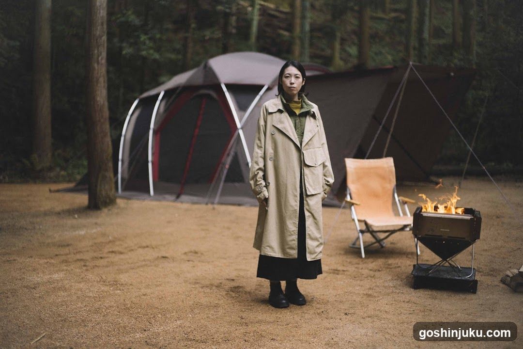 Woman in Trench Coat at Campsite