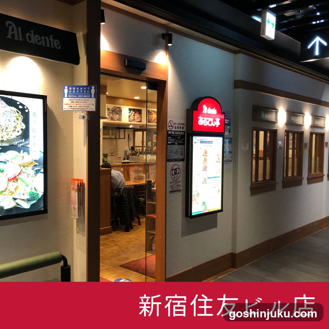 Exterior view of Al dente restaurant entrance, featuring illuminated signage and menu board on wall.