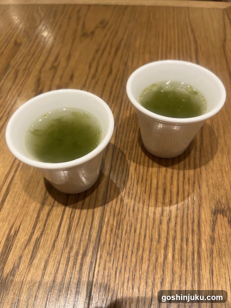 Two cups of green tea on a wooden table