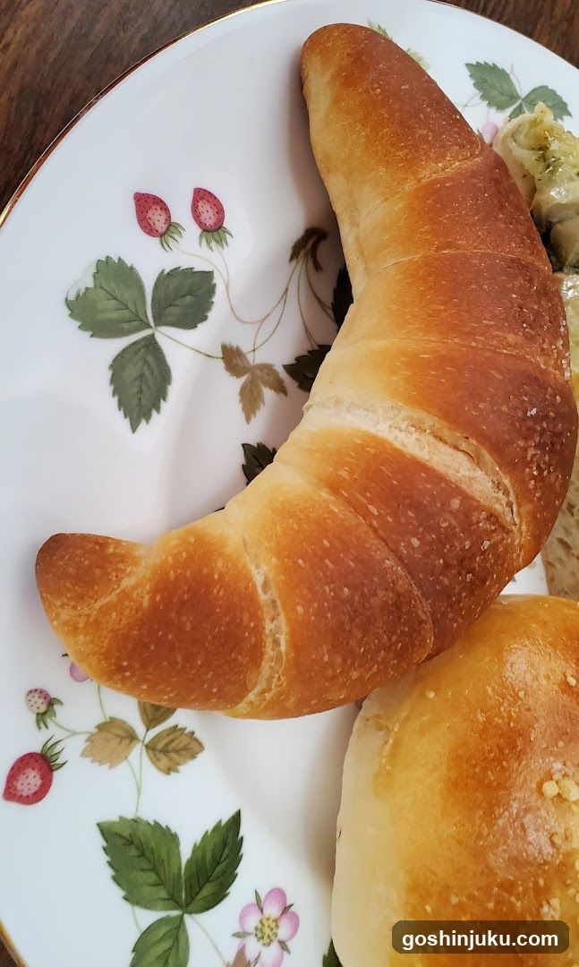 Croissant and bread on floral plate