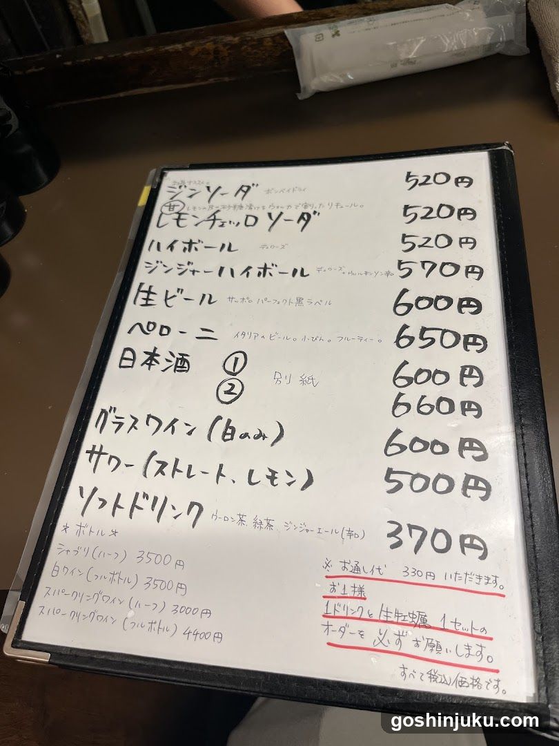 A handwritten menu board on a whiteboard in a bar or restaurant setting, listing drinks and prices.