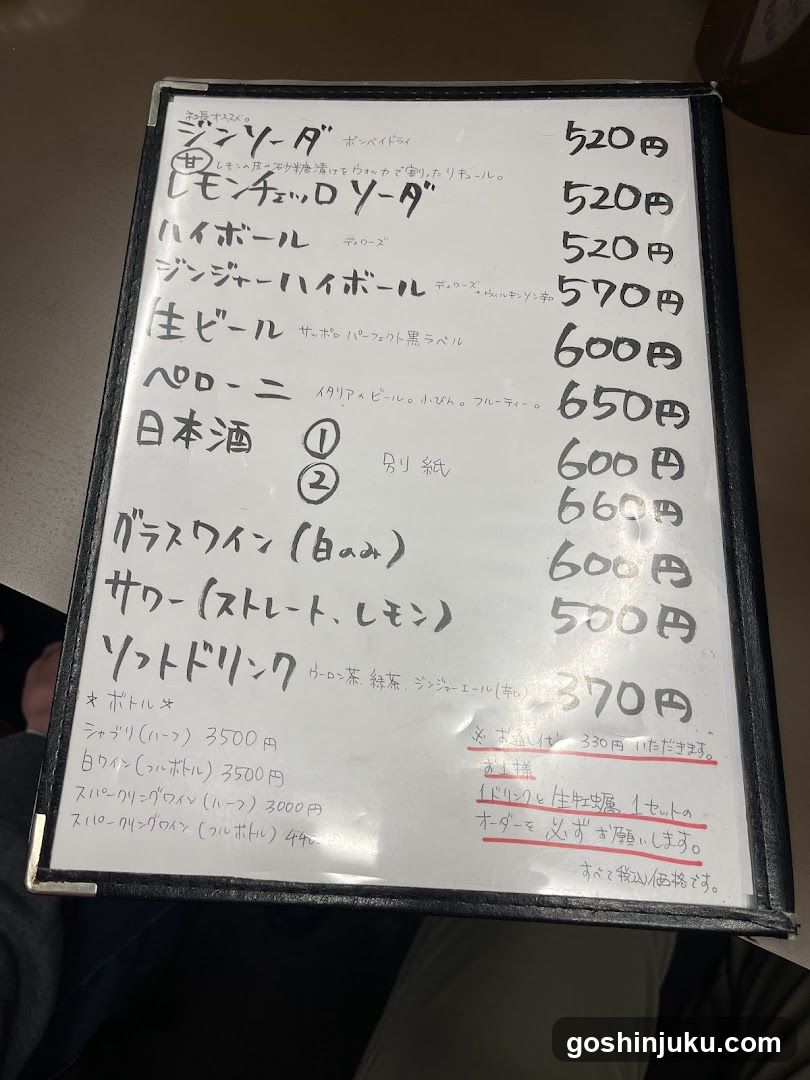 Handwritten whiteboard menu listing drinks and prices in yen, including Japanese beer, sake, wine, and soft drinks.