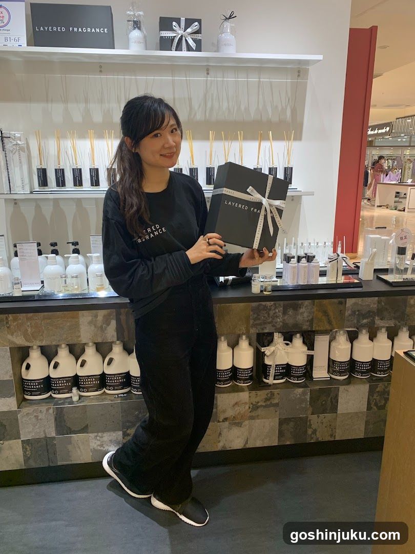Woman holding layered fragrance gift box in store