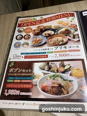 A printed menu board featuring special dishes and sets for an opening celebration, with prices in yen.