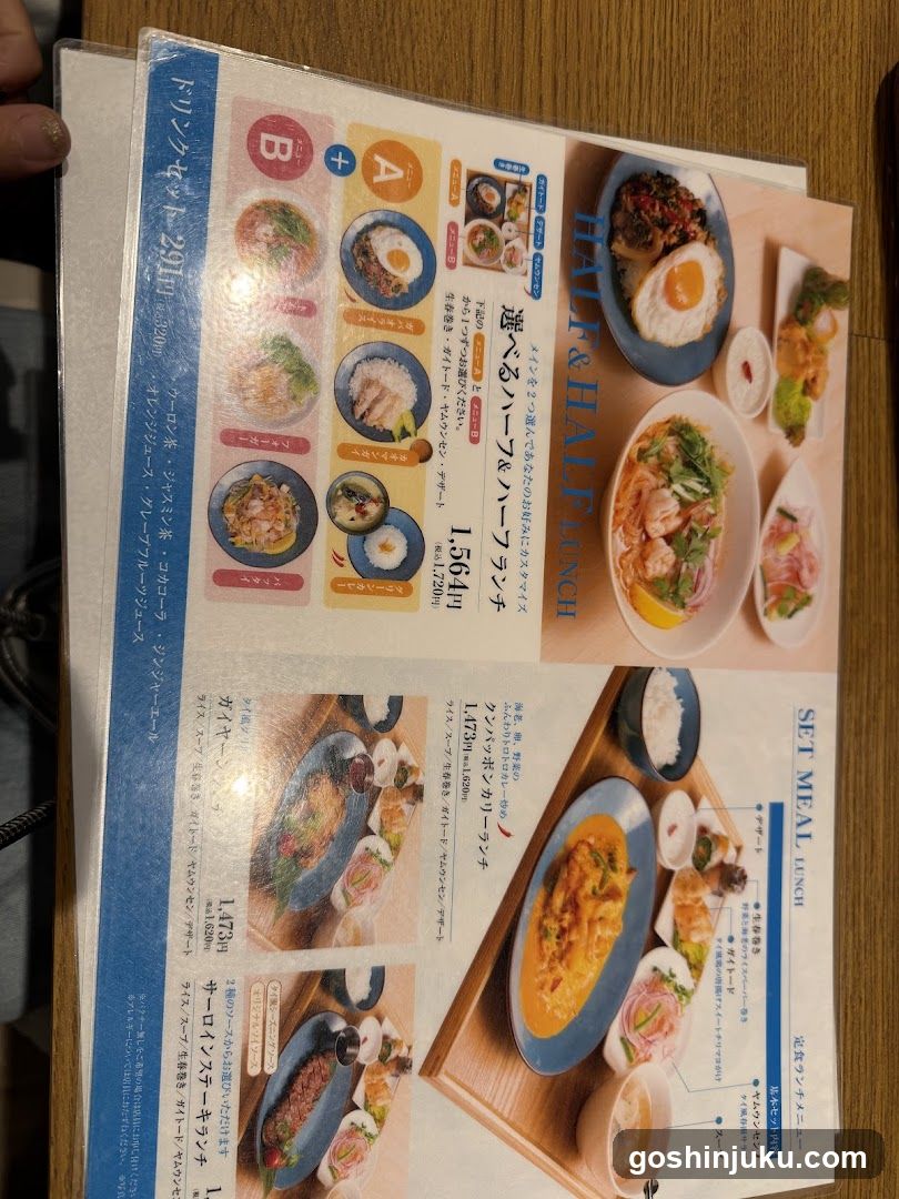 A close-up of a printed menu page from a Japanese restaurant, featuring lunch options like 'Half & Half Lunch' and 'Set Meal Lunch', with images of dishes such as fried chicken, rice bowls, and curry sets.