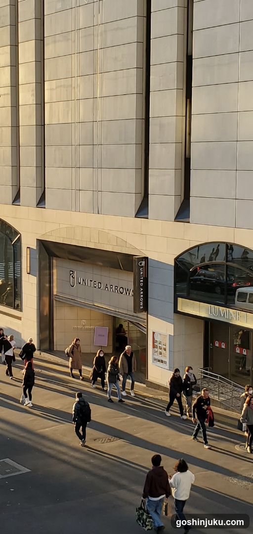 Exterior view of a United Arrows store with visible signage on the building facade. Pedestrians walking along the sidewalk in front.