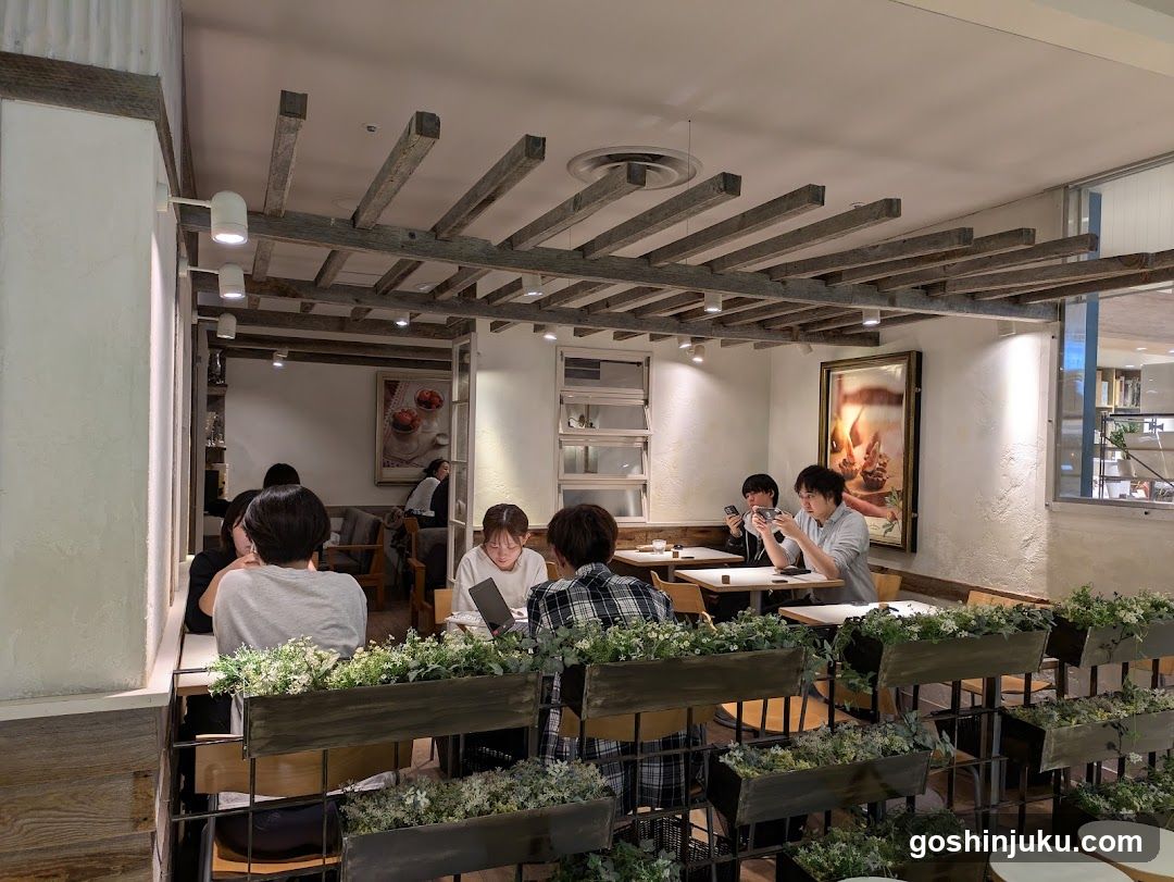 Interior of a cozy cafe with wooden beams and greenery