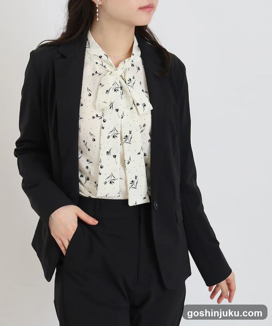 Woman in black blazer and patterned blouse